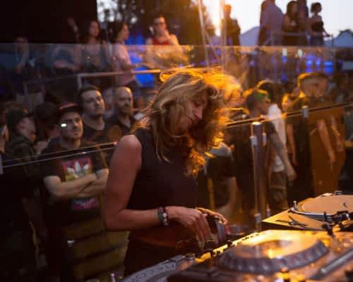 festival dj girl spinning the decks at a music festival